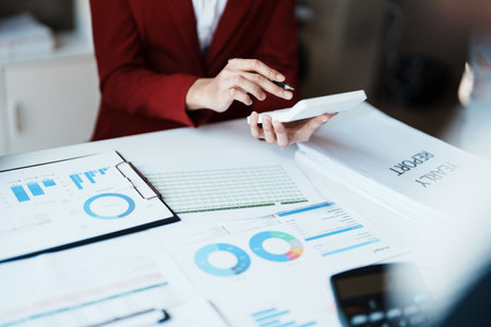 Team business adviser meeting to analyze and discuss the situation on the financial report n the meeting room with using calculator, documents, computer laptop in workの写真素材