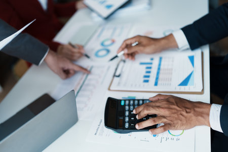 Team business adviser meeting to analyze and discuss the situation on the financial report n the meeting room with using calculator, documents, computer laptop in workの写真素材