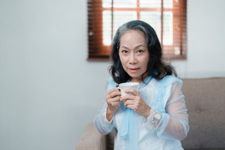 Portrait of an elderly Asian woman drinking tea for healthの写真素材