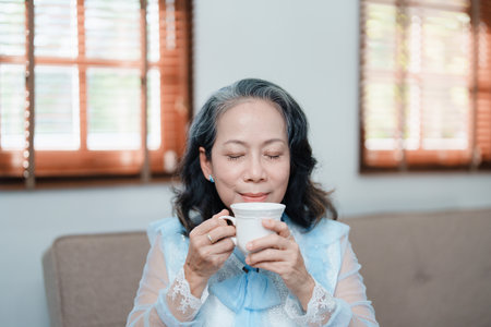 Portrait of an elderly Asian woman drinking tea for healthの写真素材