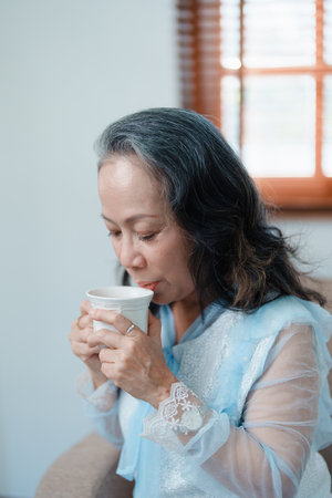 Portrait of an elderly Asian woman drinking tea for healthの写真素材