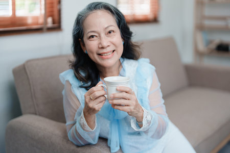 Portrait of an elderly Asian woman drinking tea for healthの写真素材