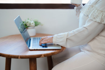 Portrait of an elderly Asian woman in a modern pose working on a computerの写真素材
