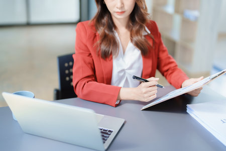 financial, Planning, Marketing and Accounting, portrait of Asian employee checking financial statements using documents and computer at work..の写真素材
