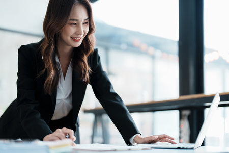 financial, Planning, Marketing and Accounting, portrait of Asian employee checking financial statements using documents and calculators at work..の写真素材