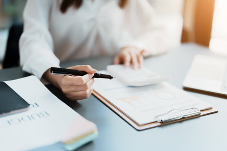 Accountants, Asian auditors are using calculators and computers to review annual tax budgets to submit information to the IRSの写真素材