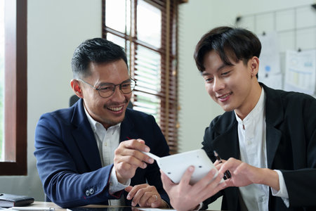 financial, Planning, Marketing and Accounting, Asian young Economist using calculator to calculate investment documents with partners on profit taking to compete with other companies.の写真素材