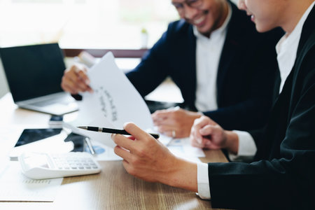 Teamwork concept, consultation, male economist using documents budget, finance and investment documents, discussing and planning finances with female advisors in conference room.の写真素材