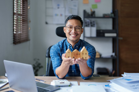 Entrepreneurs, business owners, accountants, real estate agents, A young man using a calculator to calculate his home budget to assess the risks of investing in real estate.の写真素材