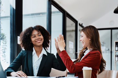 Multiethnic business, Beautiful American African and asian businesswoman people meeting Diverse Happy people celebrating success at company, teamwork, triumph, victory, achievement concept.の写真素材