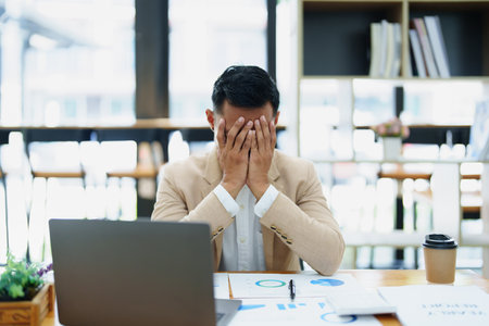 Portrait of sme business owner, man using computer and financial statements Anxious expression on expanding the market to increase the ability to invest in business.の写真素材