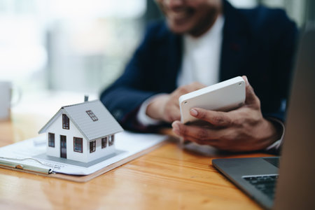 Guarantee, mortgage, contract, contract, signed,A portrait of a man showing a smiling face while using the housing price calculator to assess real estate investment risk.の写真素材