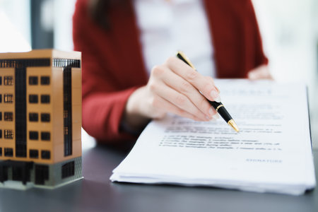 Guarantee, mortgage, agreement, contract, signed, real estate agent pointing to documents for customers to read the agreement before signing important documents.の写真素材