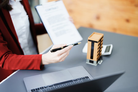 Guarantee, mortgage, agreement, contract, signed, real estate agent pointing to documents for customers to read the agreement before signing important documents.の写真素材