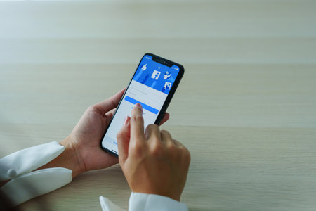Chiang Mai Thailand. Sep 08, 2022. Woman holds smart phone with facebook application on the screen. facebook is a photo-sharing app for smartphonesのeditorial素材