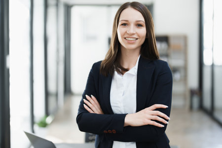 Portrait of a woman business owner showing a happy smiling face as he has successfully invested her business using computers and financial budget documents at work.の写真素材