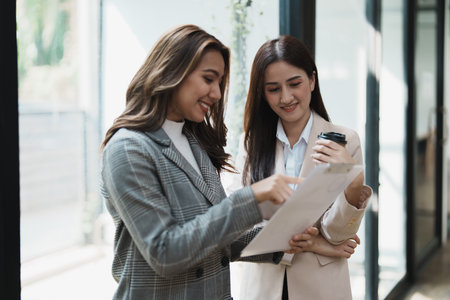 Financial analysts analyzing business reports on planned investment projects during corporate meeting discussions showcase successful teamwork with marketing plan, document to work.の写真素材