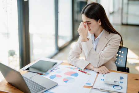Portrait of business owner, woman using computer and financial statements Anxious expression on expanding the market to increase the ability to invest in business.の写真素材