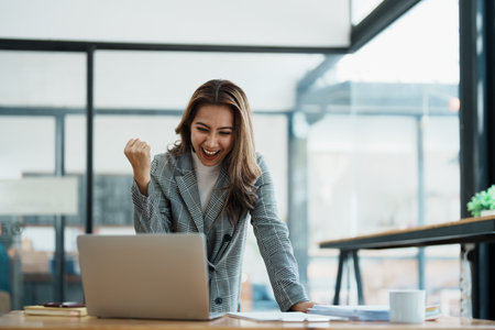 businesswoman using laptop Excited the work came out successfully and the goal was achieved.の写真素材