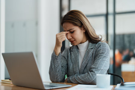 Portrait of business owner, woman using computer and financial statements Anxious expression on expanding the market to increase the ability to invest in business.の写真素材