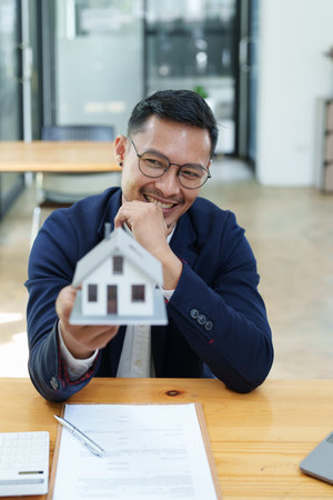 Guarantee, Mortgage, agreement, contract, Signing, Male client holding pen to reading agreement document to sign land loan with real estate agent or bank officer.の写真素材
