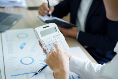 financial, Planning, Marketing and Accounting, Asian young Economist using calculator to calculate...