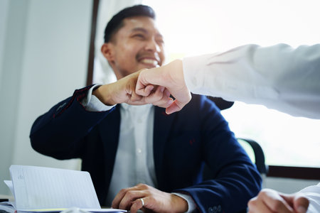 Portrait of two young Asian entrepreneurs congratulating them with smiling faces after successful investment negotiations.の写真素材
