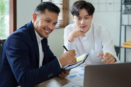 Young economists or accountants or financiers and investors are reviewing budget documents and using computers to study impact and risk assessments on corporate investment managementの写真素材