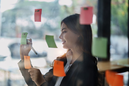 Beautiful young teen asian businesswoman using note pad thinking with planning working on financial document, tax, exchange, accounting and Financial advisor.の写真素材