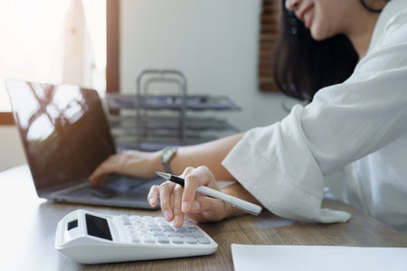 Accountants, Asian auditors are using calculators and computers to review annual tax budgets to submit information to the IRSの写真素材