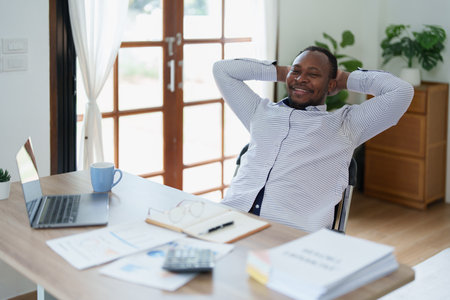 middle aged man American African business man holding computer laptop with hands up in winner is gesture, Happy to be successful celebrating achievement success.の写真素材