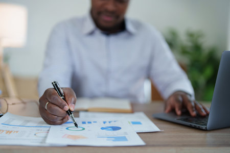 middle aged man American African using computer laptop with planning working on financial document, tax, exchange, accounting and Financial advisor. auditor or audit concepts.の写真素材