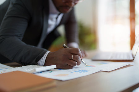 middle aged man American African using computer laptop with planning working on financial document, tax, exchange, accounting and Financial advisor. auditor or audit concepts.の写真素材