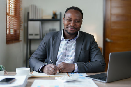 middle aged man American African using computer laptop with planning working on financial document, tax, exchange, accounting and Financial advisor. auditor or audit concepts.の写真素材