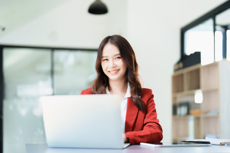 Portrait of a business woman talking on the computer and drinking coffee.の写真素材