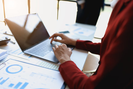 Team business adviser meeting to analyze and discuss the situation on the financial report n the meeting room with using computer laptop, documents, calculator in workの写真素材