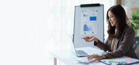 Beautiful young teen asian business woman meeting at on computer laptop with planning working on financial document, tax, exchange, accounting and Financial advisorの写真素材