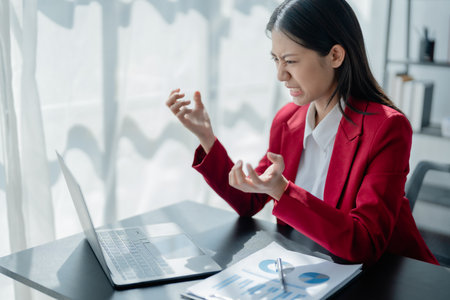 Portrait of business owner, woman using computer and financial statements Anxious expression on expanding the market to increase the ability to invest in business.の写真素材