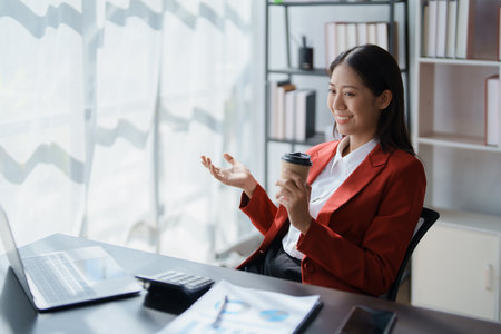Beautiful young teen asian business woman meeting at on computer laptop with planning working on financial document, tax, exchange, accounting and Financial advisor.の写真素材