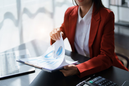 Young asian female work with financial papers at home count on calculator before paying taxes receipts online, planning budget glad to find chance for economy saving money, audit concepts.の写真素材