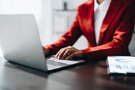 Beautiful young teen asian businesswoman using laptop computer and paperworks with planning working on financial document, tax, exchange, accounting and Financial advisor.の写真素材