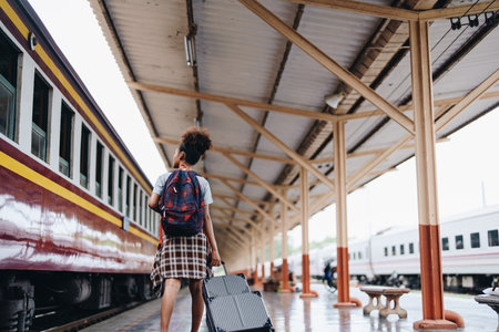 Tourists african american are showing happy expressions while waiting for their journey in the train stationの写真素材