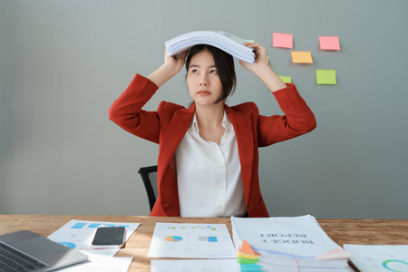 Portrait of business owner, woman using computer and financial statements Anxious expression on expanding the market to increase the ability to invest in business.の写真素材