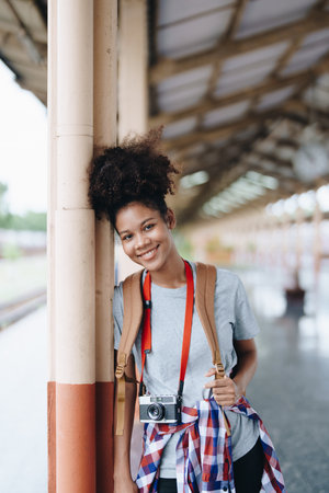 Tourists african american are showing happy expressions while waiting for their journey in the train stationの写真素材