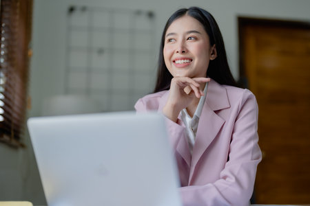 Excited businesswoman using computer laptop while in office, business conceptsの写真素材
