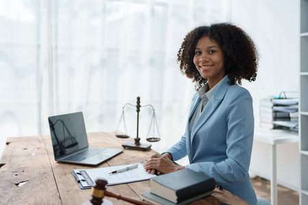 Young African American lawyer studying a case for a client and signing a legal contract to fight her opponent in court. Legal and lawyer conceptsの写真素材