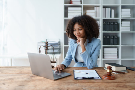 A young women African American lawyer lawsuit studying cases for clients in a law firm to fight against their parties in the courts. law and attorney conceptsの写真素材