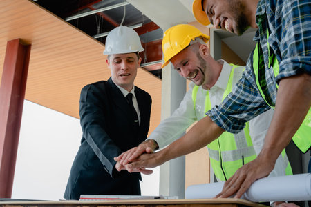 multi ethnic engineer brainstorming with deal and measuring for cost estimating on paperworks and floor plan drawings, contract and agreement concepts.の写真素材