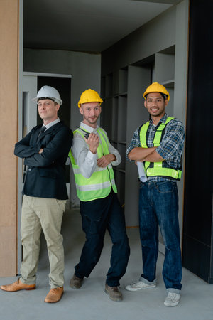 multi ethnic engineer brainstorming and measuring for cost estimating on paperworks and floor plan...