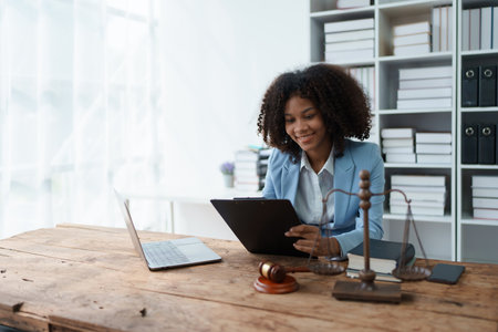 A young women African American lawyer lawsuit studying cases for clients in a law firm to fight against their parties in the courts. law and attorney conceptsの写真素材